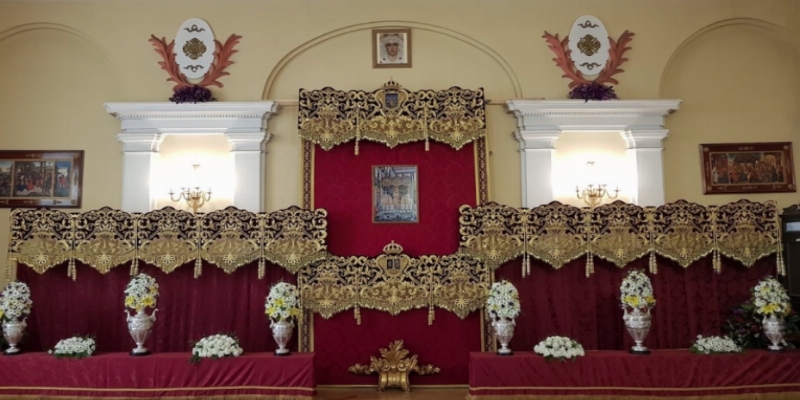 El párroco de la colegiata de San Isidro bendice las bambalinas restauradas del palio de la Macarena
